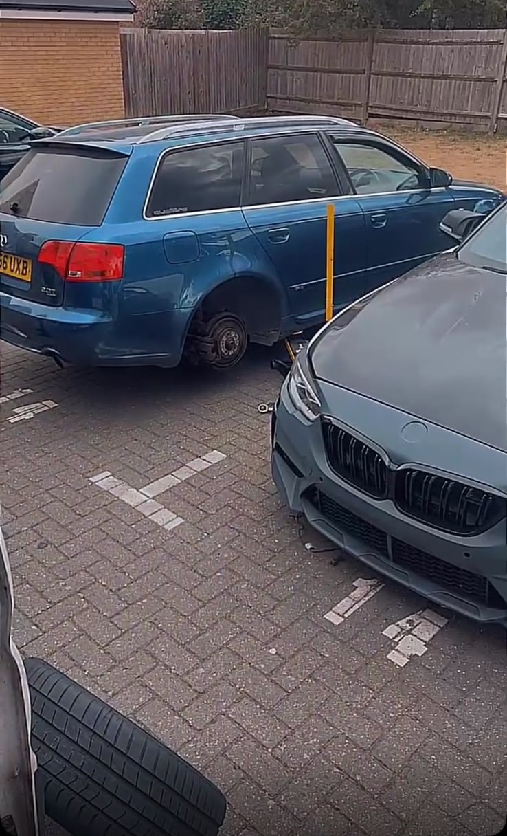 Blue Audi A4 Avant quattro on a residential driveway with its rear wheel removed during a mobile tyre change