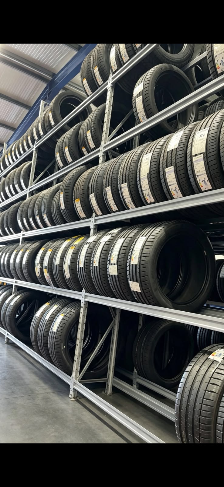 Warehouse racking stacked with premium new tyres at one of our trade suppliers
